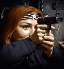 Sie schiet, senkt die Waffe und lacht 